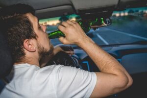 Driver drinking beer while driving.