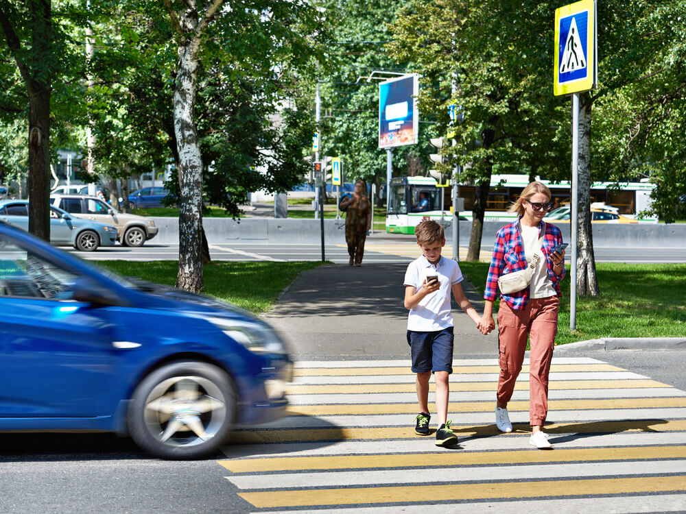 Mother and son crossing the street while texting.