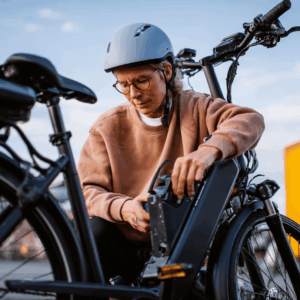 woman trying to change the battery on an electric bicycle